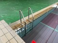 プール内のステンレス手摺付昇降台とプールサイドのステンレスラダー